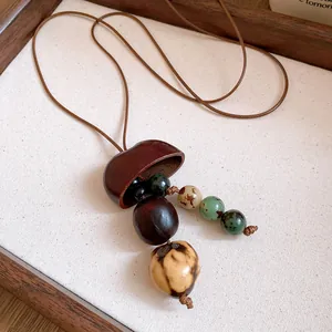 Detailed close-up of a Maillard-style necklace with wooden shell pendant and beads
