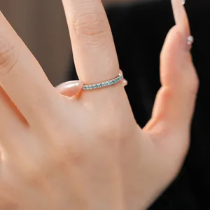 Macro view of a minimalist ultra-fine silver ring with small blue zircon row stones