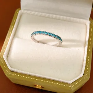 Close-up of minimalist silver eternity ring with sky blue cubic zirconia stones