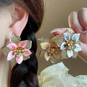 Exaggerated vintage flower stud earrings featuring colorful enamel and elegant gold finish