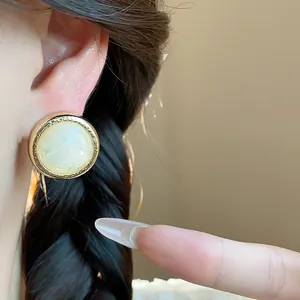 Close-up view of elegant retro geometric resin stud earring worn on model's ear lobe