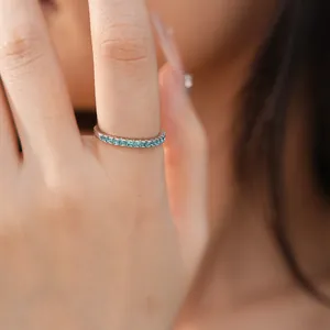 Close-up detail of a minimalist slim silver ring set with a row of blue cubic zirconia