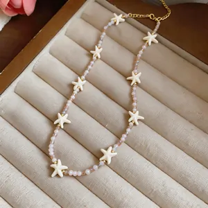 Detailweergave van de handgemaakte kralenketting met roomwitte zeesterhangers