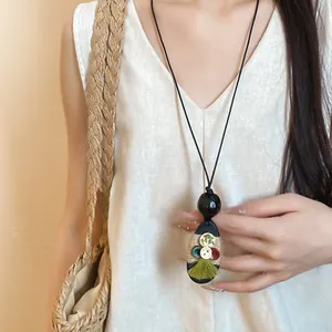 Handmade Maillard style necklace with wood pendant, hemp rope and tassel detail