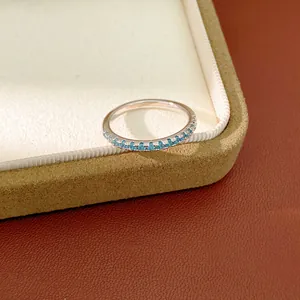 Elegant dainty silver ring with light blue zircon pavé stones shown on a jewelry box