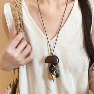 Detailed close-up of a Maillard-style necklace with wooden beads worn by an Asian model