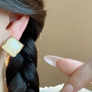 Detailed view of minimalist vintage square resin stud earrings with a gold frame