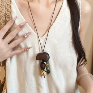 Close-up of Maillard style wooden pendant necklace with bohemian beads on a model