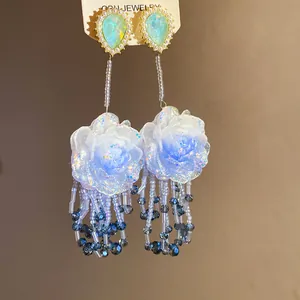 Orecchini lunghi con rose blu glitterate e eleganti nappine di perline blu marine