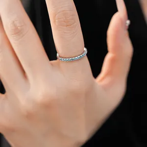 Detailed close-up view of a minimalist sterling silver eternity ring with light blue zircons