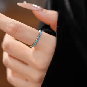 Detail shot of a minimalist silver eternity ring with sparkling light blue zircons