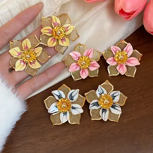 Detailed view of vintage enamel flower stud earrings in multiple colors and gold accents.