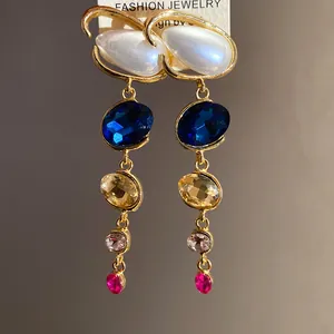 Dettaglio di orecchini a goccia vintage con cristalli colorati e perle eleganti