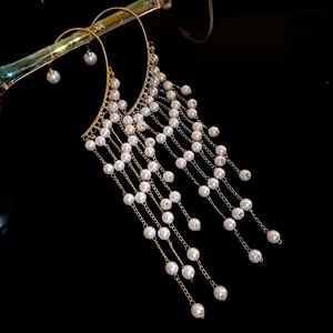 Detail of elegant golden tassel ear cuffs with white pearls in a retro luxury design.