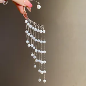 Close-up of elegant silver ear cuff featuring cascading multi-strand pearl tassels.