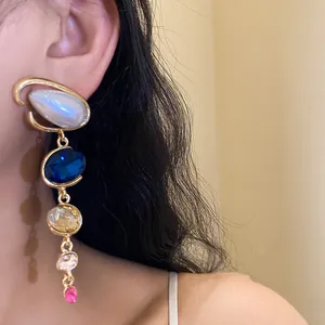 Primo piano di orecchini a goccia rétro francesi con strass colorati su una modella.