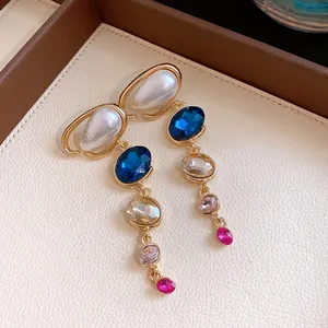 Vista dettagliata di orecchini vintage in oro con perle e cristalli multicolore