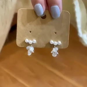 Elegant white pearl stud earrings with delicate clear crystal leaf tassel pendants