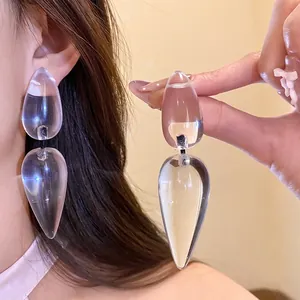 Elegant transparent resin double water drop pendant earrings shown on model's ear