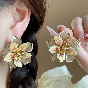 Exquisite close-up of retro floral ear studs featuring unique golden mesh and drip oil finish