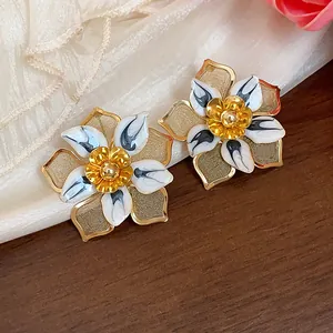 Retro floral stud earrings with gold mesh and white enamel petals detail.
