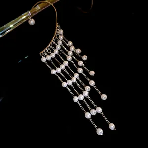 Elegant pearl tassel ear cuff with gold finish on a black background for a detail view