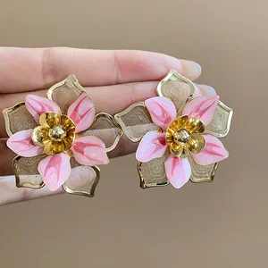 Detailed view of retro pink enamel flower stud earrings featuring gold mesh petals