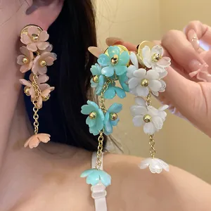 Close-up detail of multi-color acrylic floral tassel earrings with elegant long golden chains