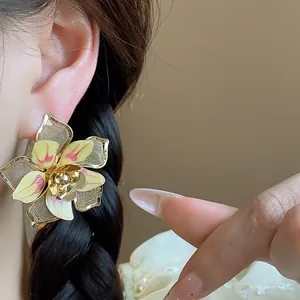 Detail view of a large vintage floral stud earring with exquisite enamel finish