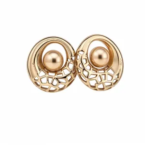 Élégantes boucles d'oreilles rondes ajourées dorées avec une perle métallique centrale.