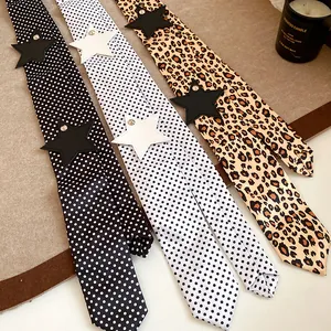 Detail view of long silk scarves with leopard and polka dot patterns with star patch.