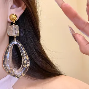 Detailed view of clear resin teardrop earrings with elegant gold foil flakes for a stylish look