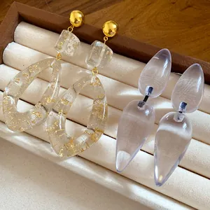 Detailed view of handmade resin teardrop earrings with gold foil and transparent finish.
