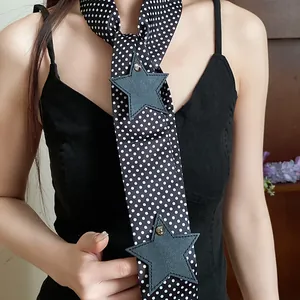 Detail shot of a black polka dot neck scarf with star patches worn by a model