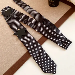 Close-up detail of black polka dot skinny scarf with black star appliqué and studs