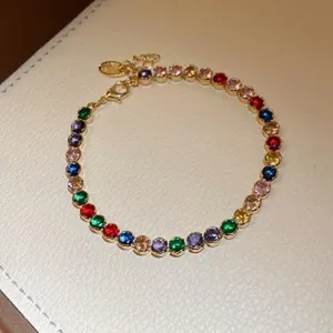 Close-up of an elegant gold-plated bracelet featuring vibrant multi-colored zircons
