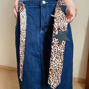 Detail of leopard print scarf tied to a denim skirt as a fashion belt accessory