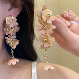 Detail of elegant acrylic flower tassel earrings with golden beads and petals