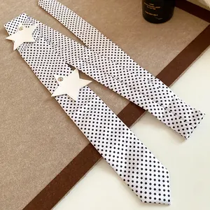Detailed view of a white polka dot hair ribbon featuring chic white star accents.