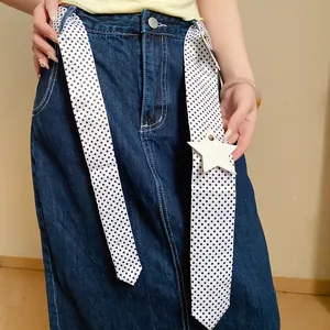Detail view of Korean style long polka dot ribbon scarf with a star pendant accessory.