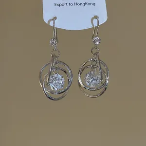 Macro detail of stylish silver multilayer round earrings featuring clear zircon balls