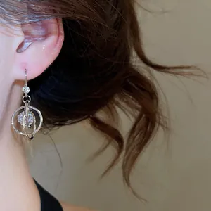 Close-up of multi-layer zircon round dangle earrings worn on ear with soft lighting