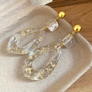 Macro detail shot of resin teardrop earrings with elegant gold foil flakes inside
