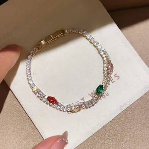 Close-up of a gold-plated bracelet with sparkling multi-colored cubic zirconia.