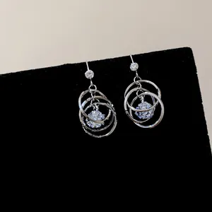 Close-up of multi-layer circular dangle earrings with sparkling central cubic zirconia