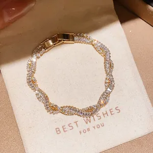 Detailed view of elegant gold-plated wavy bracelet set with sparkling cubic zirconia stones