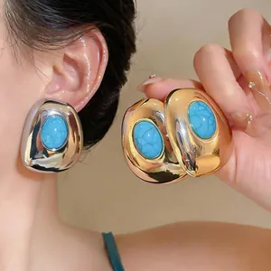 Close-up detail of vintage geometric oval resin stud earrings in gold and silver finish
