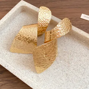 Detailed view of gold irregular twisted earrings showing unique wrinkled metal texture