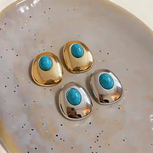 Macro detail of palace style geometric oval stud earrings with turquoise resin stones