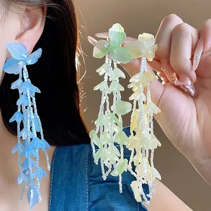 Detailansicht von handgefertigten Glasblumen-Quastenohrringen in Blau, Grün und Gelb.